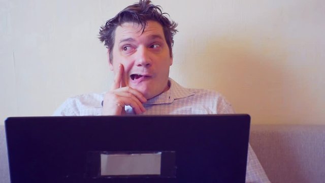 crazy man thinks sitting behind laptop