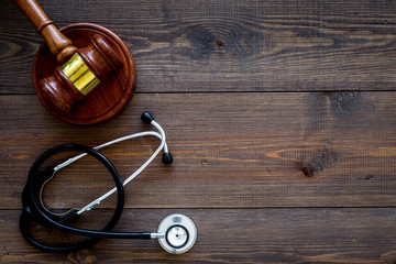 Medical law, health law concept. Gavel and stethoscope on dark wooden backgound top view copy space
