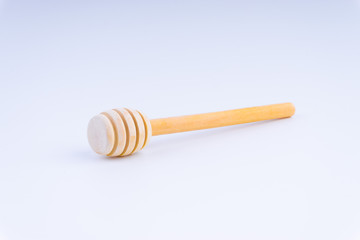 Wooden honey dipper on white background. 