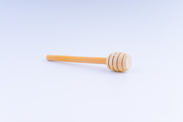 Wooden honey dipper on white background. 