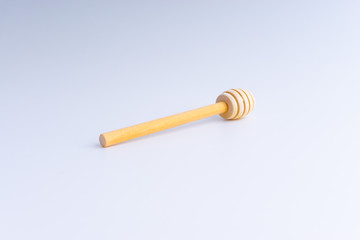 Wooden honey dipper on white background. 