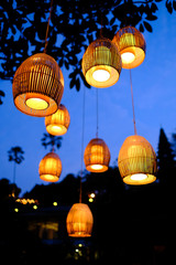Traditional Balinese lanterns hanging from a tree lighting up Ubud, Indonesia