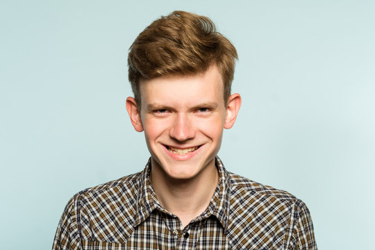 murderous psycho smile. crazy killer lunatic man grinning. portrait of a young guy on light background. emotion facial expression. feelings and people reaction.
