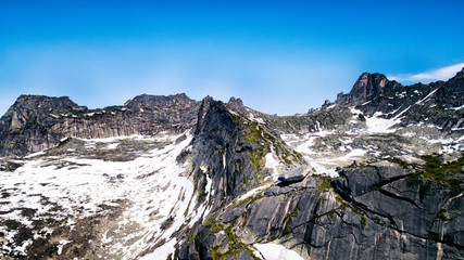 Snow-covered black mountains blue sky Hanging stone, Natural Park Ergaki