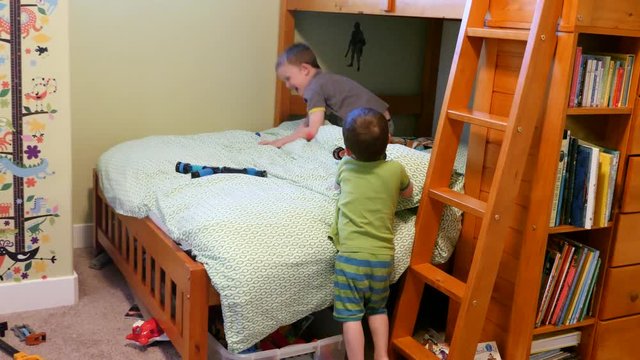 Adorable brothers playing with nerf guns in a bedroom