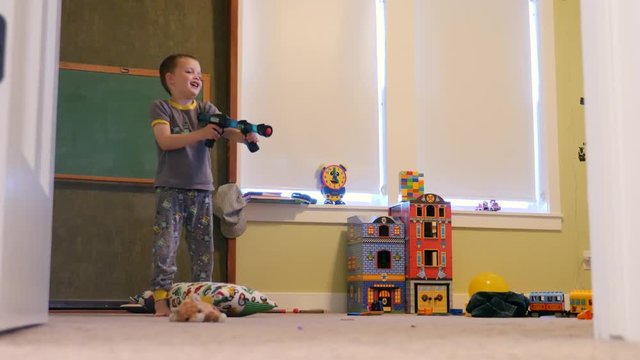 Adorable brothers playing with nerf guns in their bedroom