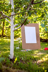 blank white sheet on a drawing board. Drawing in the open air. Summer activity, art paint. Blossoming garden, inspiration, drawing by paints
