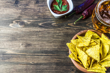 Nachos corn chips with classic tomato salsa. Fresh cold beer is perfect with savory snacks.