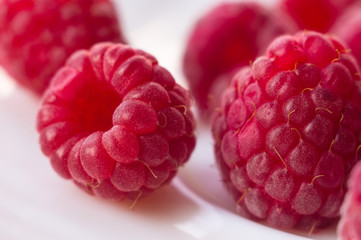 raspberries on a white saucer close up