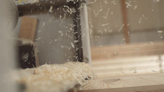slow motion wood shavings fly in the air. woodworking close-up