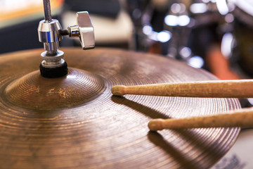 Fototapeta na wymiar Pair of drumsticks lying on cymbal.