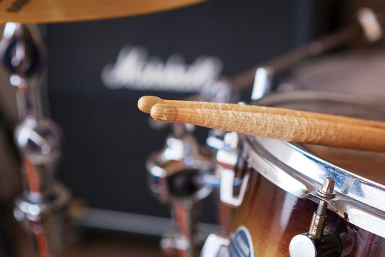 Pair of drumsticks lying on tom-tom drum.
