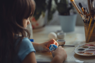 Girl painting on  the easter egg