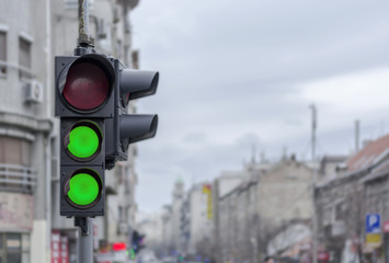 Two green semaphore light in Ccity urban blury background