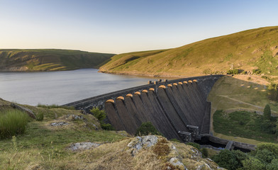 Claerwen Reservoir and dam, in the Elan Valley, mid Wales. The sun is setting and the sky is beginning to turn a deep blue