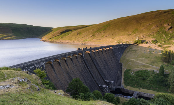 Claerwen Reservoir and dam, in the Elan Valley, mid Wales. The sun is setting and the sky is beginning to turn a deep blue