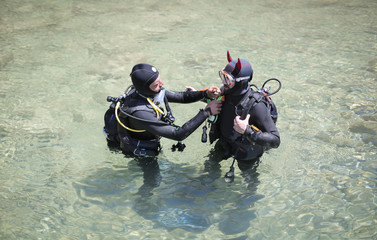 Fototapeta na wymiar Scuba divers checking each other equipments
