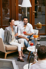 Couple Smoking Shisha And Drinking Cocktails In Hookah Bar