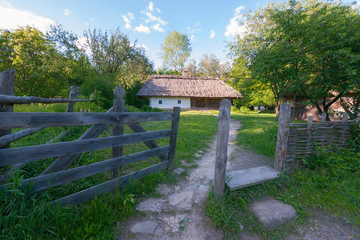 wooden gateway to the courtyard with a white, authentic home garden near the garden. Uzhhorod Ukraine