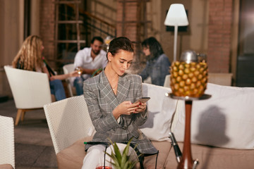 Woman With Phone Smoking Fruit Hookah In Shisha Bar