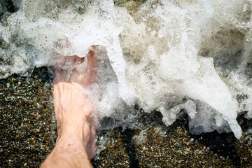 man's foot in sea water