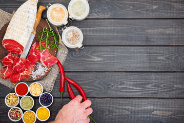 Sliced cured coppa with spices and a sprig of rosemary.