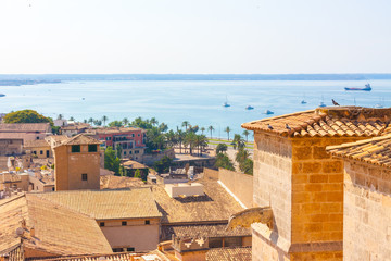 Naklejka premium View over the rooftops of Palma de Mallorca with the sea in the background from the terrace of the Cathedral of Santa Maria of Palma, also known as La Seu. Palma, Majorca, Spain
