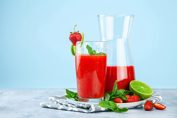 Strawberry cocktail with mint and lime on blue background. Close up view. Copy space for text. 