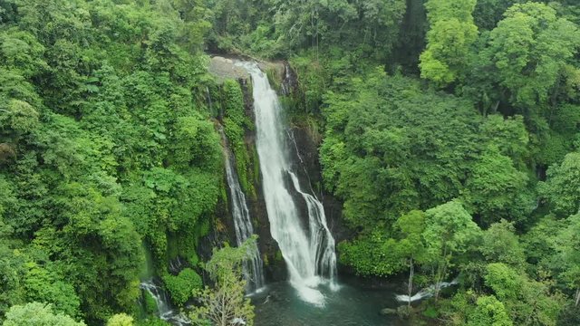 Aerial shot flying towards a beautiful secluded waterfall in the Balinese jungle. Drone shot, Bali; Indonesia