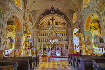 Obraz premium A very beautiful church inside with an altar set with icons, with painted holy walls and frescoes and paintings on the ceiling and pillars.