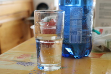 Sparkling water in a glass with bottle in background.JPG