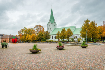 Dobele. Latvia. Autumn landscape with church and ancient market square with fountain.
