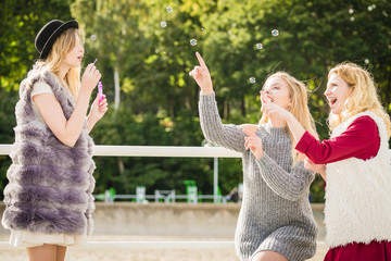 Women friends blowing soap bubbles.