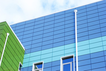 Part of modern green and blue building, a view from the bottom in perspective