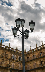 Traditional street lamp on the famous and historic Plaza Mayor in Salamanca with dramatic clouds, Castilla y Leon, Spain - UNESCO