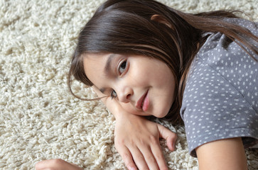 beautiful girl lies on a fluffy carpet