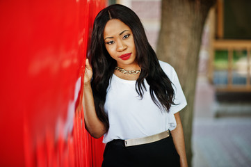 Stylish african american business woman with handbag on streets of city.