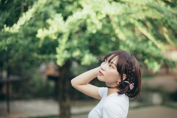 portrait of asian girl with white shirt and skirt looking in outdoor nature vintage film style