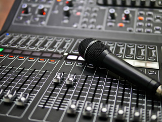 microphone rests on an audio mixer controller in the control room, Sound mixer control for live...