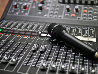 microphone rests on an audio mixer controller in the control room, Sound mixer control for live music and studio equipment, music equipment concept