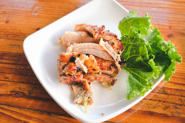 Grilled chicken on the white plate.