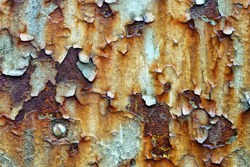 Cracked paint on an old  metal surface,  texture of rusty iron, surface with a bolt