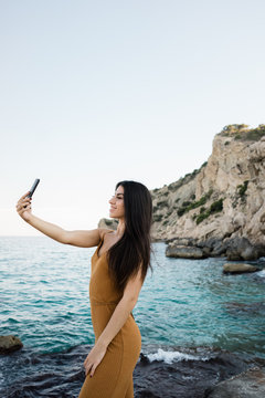 Stylish woman taking selfie on beach