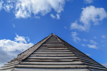Fototapeta na wymiar Wooden old rusty roof pattern with blue cloudy sky