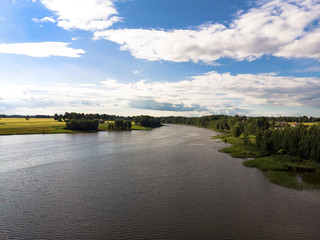 Fototapeta premium Beautiful lake with trees on the sides and bright blue cloudy sky. Beautiful nature landscape