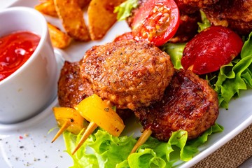 Meatballs skewers of tomato, paprika and baked potato quarters