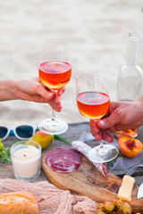 Picnic on beach at sunset in boho style. Romantic dinner, friends party, summertime, food and drink concept