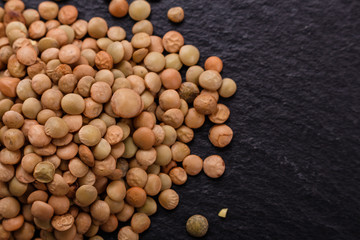 raw lentils on a dark stone background