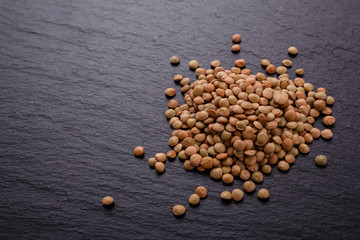 raw lentils on a dark stone background