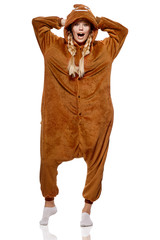 A pretty girl in a funny brown kigurumi featuring poop emoji on the hood. The attractive blonde...